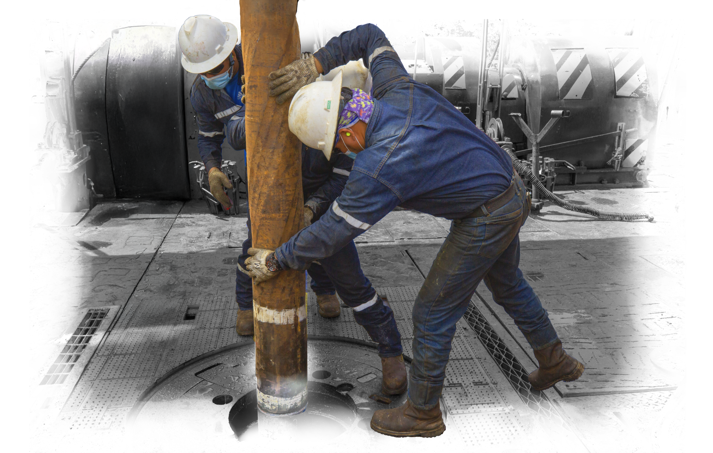Trabajadores petroleros manipulan una tubería en un pozo